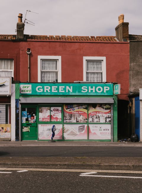 Exterior view of a small laundrette on Tufnell Park Road operated by Carpet Cleaners N7, featuring a white wooden façade with blue vertical signage reading 'LAUNDERETTE' on both sides of the entrance